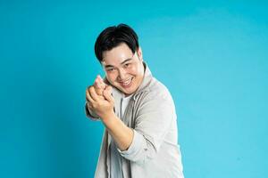 ritratto di un asiatico tipo in posa su un' blu sfondo foto