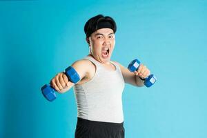 Immagine di asiatico uomo esercizio su blu sfondo foto