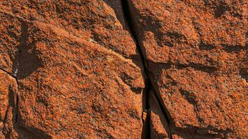 buio rosso arancia Marrone roccia struttura con crepe. avvicinamento. ruvido montagna superficie. ai generativo. foto