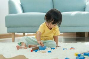 contento asiatico bambino giocando e apprendimento giocattolo blocchi. bambini siamo molto contento e eccitato a casa. bambino avere un' grande tempo giocando, attività, sviluppo, Attenzione disavanzo iperattività disturbo foto