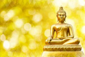 bellissimo di d'oro Budda statua su d'oro giallo bokeh sfondo. foto