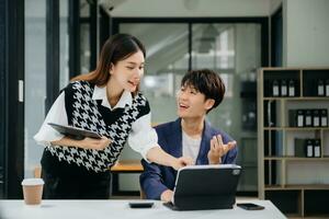 Due asiatico donna d'affari e uomo discutere investimento progetto Lavorando e pianificazione strategia con tavoletta il computer portatile computer nel ufficio. foto