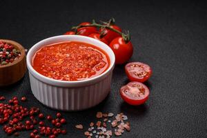 delizioso caldo speziato rosso salsa con sale e spezie nel un' ceramica ciotola foto