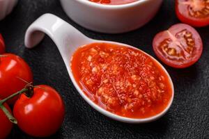 delizioso caldo speziato rosso salsa con sale e spezie nel un' ceramica ciotola foto