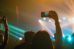 persone Tenere inteligente Telefono e registrazione e Fotografare nel concerto , silhouette di mani con mobile , evento sfondo concetto foto