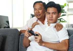 padre e figlio che giocano felicemente ai videogiochi a casa in vacanza