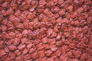 astratto muro di cemento rosso texture di sfondo. sfondo di un esterno rivestito in stucco rosso e dipinto foto