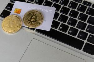 crypto bitcoin e carta di credito sulle tastiere dei computer. finanza nel mondo digitale moderno foto