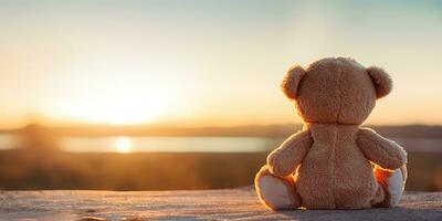 ai generato. ai generativo. solo mancante uno giocattolo Bambola poco orso seduta guardare su tramonto sfondo paesaggio all'aperto. grafico arte foto