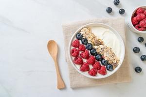 ciotola di yogurt fatta in casa con lampone, mirtillo e muesli - stile alimentare sano foto
