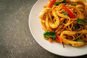 spaghetti saltati in padella con uova salate e calamari - stile fusion foto