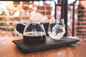 barattolo di caffè nero a goccia fredda con vetro e ghiaccio nella caffetteria e nel ristorante foto