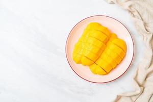 mango fresco e dorato affettato sul piatto foto