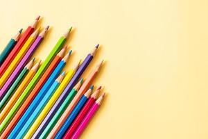 matite colorate su sfondo giallo con copia spazio foto