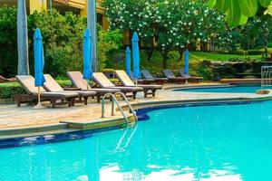 sedie piscine e ombrelloni intorno alla piscina con palme da cocco - vacanze e concetto di vacanza vacation foto