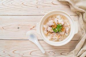 zuppa di porridge o riso bollito con scodella di pesce foto