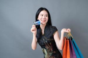 donna asiatica indossa abiti tradizionali cinesi con borsa della spesa e carta di credito foto
