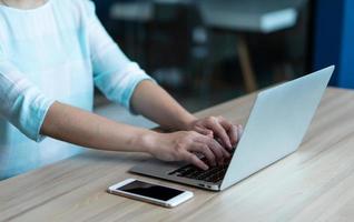 primo piano immagine delle mani della donna che digitano sulla tastiera del computer per lavorare da casa. concetto di business e freelance foto