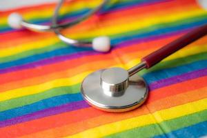 stetoscopio nero su sfondo bandiera arcobaleno, simbolo del mese dell'orgoglio lgbt celebra annuale a giugno sociale, simbolo di gay, lesbiche, bisessuali, transgender, diritti umani e pace. foto