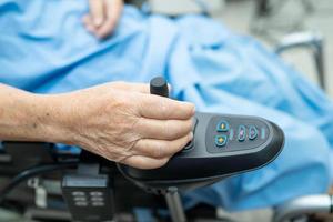 paziente asiatico anziana o anziana signora anziana su sedia a rotelle elettrica con telecomando nel reparto ospedaliero di cura, concetto medico sano e forte foto