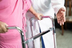 il medico aiuta e cura la donna anziana asiatica anziana o anziana usa il camminatore con una buona salute mentre cammina in ospedale. foto