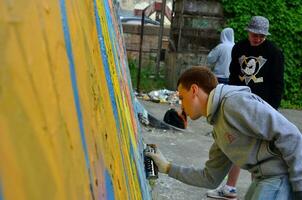 Kharkov, Ucraina - Maggio 27, 2017 Festival di strada arti. giovane ragazzi disegnare graffiti su un vecchio calcestruzzo muri nel il centro di il città. il processi di pittura su muri con aerosol spray lattine foto
