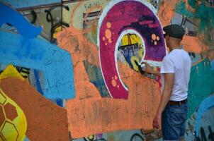 Kharkov, Ucraina - Maggio 27, 2017 Festival di strada arti. giovane ragazzi disegnare graffiti su un vecchio calcestruzzo muri nel il centro di il città. il processi di pittura su muri con aerosol spray lattine foto