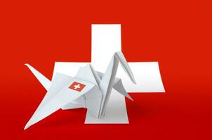 Svizzera bandiera raffigurato su carta origami gru ala. fatto a mano arti concetto foto