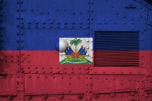 Haiti bandiera raffigurato su lato parte di militare blindato serbatoio avvicinamento. esercito forze concettuale sfondo foto