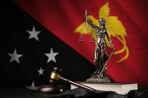 papua nuovo Guinea bandiera con statua di signora giustizia, costituzione e giudice martello su nero drappeggio. concetto di giudizio e colpa foto