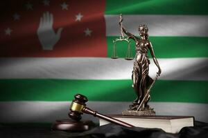 abkhazia bandiera con statua di signora giustizia, costituzione e giudice martello su nero drappeggio. concetto di giudizio e colpa foto