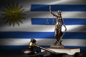 Uruguay bandiera con statua di signora giustizia, costituzione e giudice martello su nero drappeggio. concetto di giudizio e colpa foto