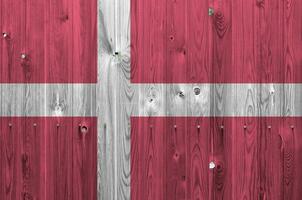 Danimarca bandiera raffigurato nel luminosa dipingere colori su vecchio di legno parete. strutturato bandiera su ruvido sfondo foto