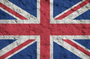 grande Gran Bretagna bandiera raffigurato nel luminosa dipingere colori su vecchio sollievo intonacatura parete. strutturato bandiera su ruvido sfondo foto