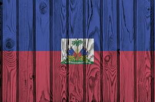 Haiti bandiera raffigurato nel luminosa dipingere colori su vecchio di legno parete. strutturato bandiera su ruvido sfondo foto