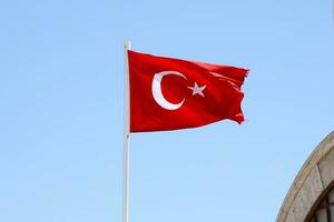 Turco bandiera su pennone agitando nel pulito blu cielo sfondo foto