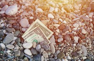 uno dollaro metà coperto con il giro rocce menzogna su spiaggia foto