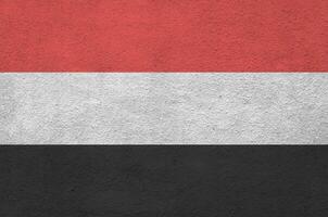 yemen bandiera raffigurato nel luminosa dipingere colori su vecchio sollievo intonacatura parete. strutturato bandiera su ruvido sfondo foto