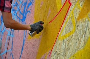 Kharkov, Ucraina - Maggio 27, 2017 Festival di strada arti. giovane ragazzi disegnare graffiti su portatile di legno muri nel il centro di il città. il processi di pittura su muri con aerosol spray lattine foto