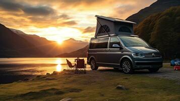 famiglia campeggio auto partire su vacanza nel un' camper, parcheggiata Il prossimo per il fiume, con il montagne dietro a il tramonto. foto