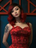 un' donna con rosso capelli e tatuaggi in posa per il telecamera generativo ai foto