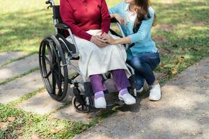 famiglia relazione asiatico anziano donna nel sedia a rotelle con contento figlia Tenere badante per un' mano mentre la spesa tempo insieme foto