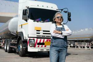 attività commerciale proprietario in piedi nel davanti di olio camion dopo l'esecuzione un' pre-viaggio ispezione su un' camion. concetto di preventivo Manutenzione. foto