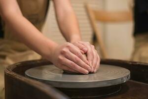 vasaio ragazza lavori su di vasaio ruota, fabbricazione ceramica pentola su di argilla nel ceramica laboratorio foto