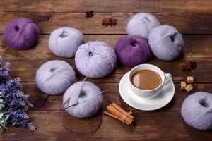 grovigli di fili di lana e raggi con una tazza di caffè e zucchero su uno sfondo di legno