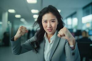 asiatico donna d'affari mostrando un' combattente posa, bellissimo manager gesti raccolta pugni nel moderno ufficio, femmina imprenditore lotte un' problema, celebrare successo e raggiungimento obiettivi foto