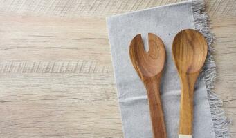 Due di legno cucchiai su un' grigio tessile cucina asciugamano su un' di legno sfondo, superiore Visualizza foto
