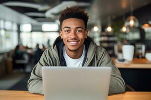 ritratto di allegro nero maschio alunno apprendimento in linea nel caffè negozio, giovane africano americano uomo studi con il computer portatile nel bar, fare compiti a casa foto