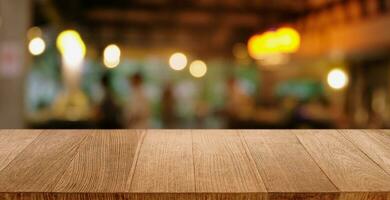 vuoto di legno tavolo nel davanti di astratto sfocato sfondo di caffè negozio . può essere Usato per Schermo o montaggio il tuo prodotti.mock su per Schermo di Prodotto. foto