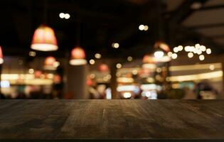 finto su per spazio. vuoto buio di legno tavolo nel davanti di astratto sfocato bokeh sfondo di ristorante . può essere Usato per Schermo o montaggio il tuo Prodotto foto
